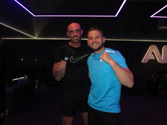 Baki smiling with a boxing student wearing gloves